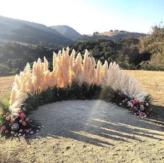 an arrangement of flowers and grass in the middle of a field