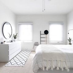 a bedroom with white walls and carpeted flooring