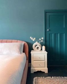 a white bed sitting next to a green door