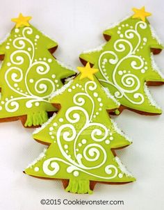 three decorated cookies in the shape of christmas trees