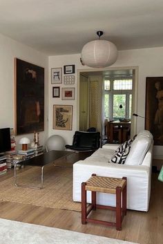 a living room filled with furniture and pictures on the wall