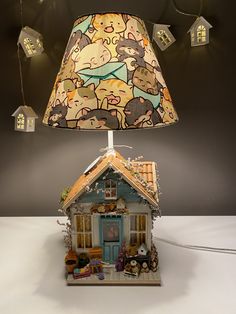 a lamp that is sitting on top of a table with a house in the background