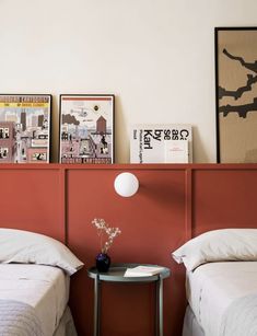 two twin beds in a bedroom with red headboards and white linens on the bed