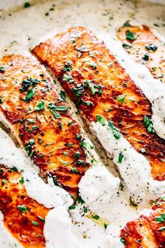 grilled salmon with cream sauce and parsley on top in a skillet, ready to be eaten