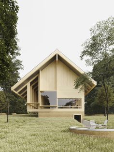 a wooden house sitting on top of a lush green field