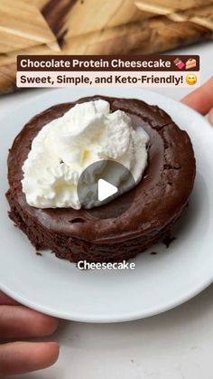 someone is holding a chocolate protein cheesecake on a plate with whipped cream in the center