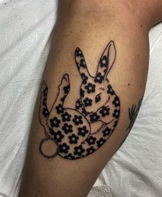 a black and white rabbit tattoo on the arm