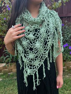 Embrace the magic of nature with the Floral Web Wrap Shawl; a hand-crocheted masterpiece adorned with intricate floral patterns and whimsical fringe, in a gorgeous seafoam green. This generously sized triangle shawl offers the perfect blend of style and comfort, effortlessly elevating your look, whether you're dancing under festival lights or savoring a cool evening outdoors. Crafted from soft, lightweight yarn, it drapes beautifully over your shoulders, providing cozy warmth without sacrificing Spring Bohemian Crochet Shawl, Bohemian Crochet Lace Shawl For Spring, Bohemian Shawl With Crochet Lace, Spring Festival Crochet Shawl, Handmade Bohemian Shawl For Spring, Crochet Shawl For Spring Festival, Green Shawl For Beach In Spring, Green Shawl For Spring Beach Outings, Green Shawl For Spring Beach Occasions