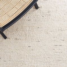 a cat laying on top of a wooden chair next to a white carpeted floor