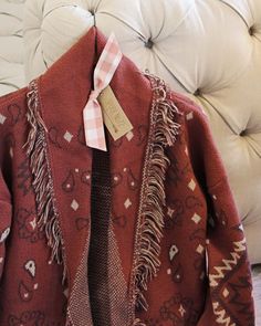 The softest knit base pairs with a western paisley print, blanket fringe & an easy long fit. Cozy long fit with an open front & soft fringe fold over collar. Color: Red rock, cream & brown Acrylic/poly blend Hand wash cold Model is a size 8 wearing a medium. Small Medium Large Bust 42 44 46 Waist 42 44 46 Hips 44 46 48 Length 32 32 32 Bust, waist, and hip measurements are a total circumference. Length is measured from the top of the shirt to the hem. Measurements are an estimate. Bohemian Jacquard Knit Outerwear For Fall, Cozy Fringe Outerwear For Fall, Western Winter Outerwear With Fringe, Blanket Sweater, Large Bust, Red Rock, Front Open, Paisley Print, Soft Knits