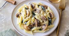 a white plate topped with pasta covered in mushrooms