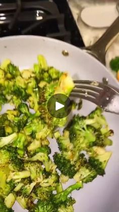 a white plate topped with broccoli on top of a stove