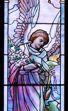 a stained glass window with an angel holding a flower