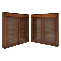 two wooden bookcases with glass doors on the front and back, one open