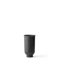 a black cup sitting on top of a white table