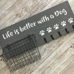 a sign that says life is better with a dog and paw prints on the front