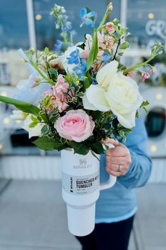 a woman holding a bouquet of flowers in her hands