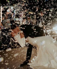 a bride and groom kissing in front of bubbles