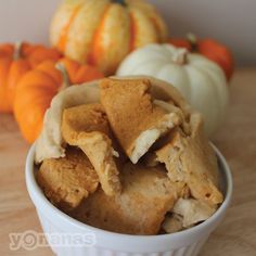 a white bowl filled with food next to pumpkins