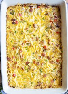 a casserole dish with meat and cheese in it on a table next to utensils