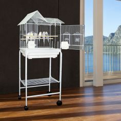 a white bird cage sitting on top of a wooden floor