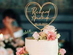 a wedding cake with a heart shaped sign on top