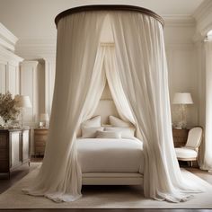 a canopy bed with white drapes in a bedroom