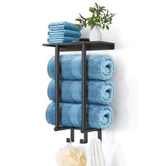 a black shelf with towels on it and a potted plant