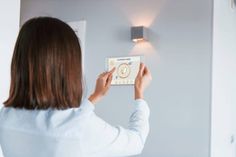 a woman is using the light switch in her home