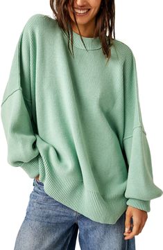 a woman wearing a green sweater and jeans