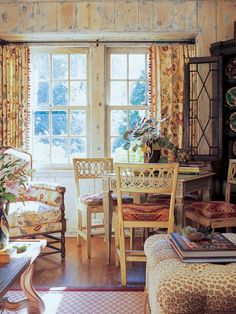 a living room filled with furniture next to a window covered in curtains and drapes