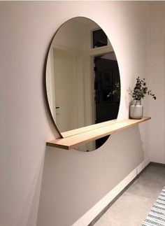 there is a mirror on the wall in this room and it looks like an oval mirror