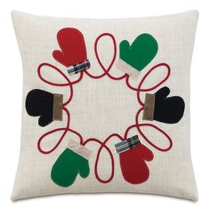 an embroidered pillow with mittens and gloves on it in the shape of a circle