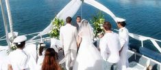 a bride and groom walking down the aisle to their wedding ceremony on a boat in the water