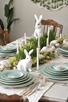 an easter table setting with bunny figurines on the dining room table and candles