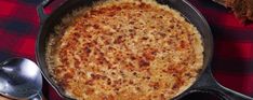 a pan filled with food sitting on top of a red and black checkered table cloth