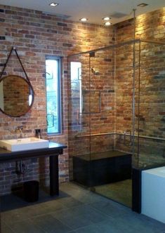 a bathroom with brick walls and a glass shower