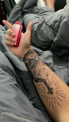 a person with a tattoo on their arm is holding a red object in one hand