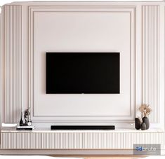 a flat screen tv mounted to the side of a white wall next to vases