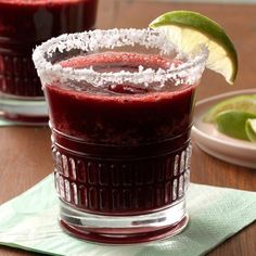 two glasses filled with red liquid and garnished with sugar on the rims