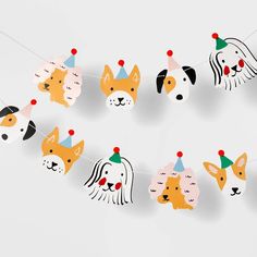 a dog party garland with dogs wearing hats on it's head, hanging from a string