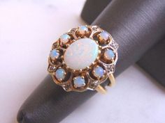 FOR SALE IS THIS UNIQUE WOMEN'S VINTAGE ESTATE 14K GOLD OPAL & DIAMOND RING. THE RING IS A SIZE 6.25 AND WEIGHS 10.0g. NOT SURE IF THE OPALS ARE REAL OR MANMADE. THE CENTER STONE IS ABOUT 2.0cts. THE DIAMONDS ARE REAL AND THERE ARE ABOUT .08cts. RING IS NOT MARKED BUT IT HAS BEEN TESTED. THE RING MAKES A BEAUTIFUL, GIFT FOR THAT SOMEONE SPECIAL. ANY OTHER QUESTIONS, PLEASE ASK. BE SURE TO CHECK OUT SOME OF MY OTHER GREAT ITEMS UP FOR SALE. THANK YOU. Antique Multi-stone Opal Ring For Wedding, Victorian Yellow Gold Opal Wedding Ring, Victorian Yellow Gold Opal Ring For Wedding, Vintage Multi-stone Opal Wedding Ring, Antique Multi-stone Opal Wedding Ring, Antique Multi-stone Opal Ring For Anniversary, Opal Diamond Ring, Chalcedony Ring, Yellow Gold Diamond Ring