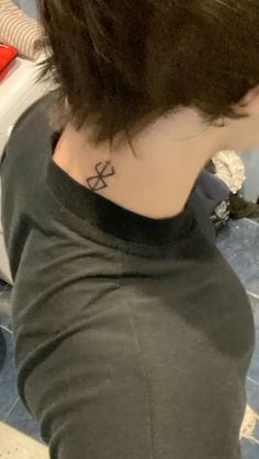 the back of a woman's neck with a small tattoo on her left side