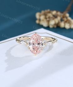 an oval shaped pink diamond ring with diamonds around it