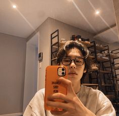 a person taking a selfie with an orange case