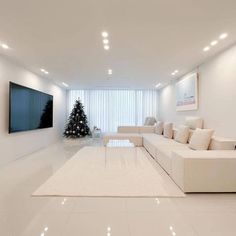 a living room filled with white furniture and a christmas tree in the middle of it