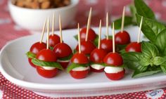 small appetizers with tomatoes, mozzarella and basil on a white plate