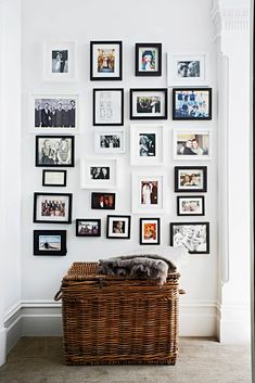 a wicker basket is sitting in front of a wall with many pictures on it