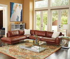 a living room filled with lots of furniture next to a large glass table on top of a rug