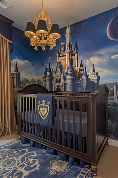 a baby's room decorated in blue and gold with a castle mural on the wall